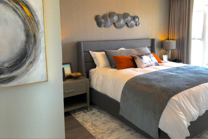 Condo bedroom designed with greys and white
